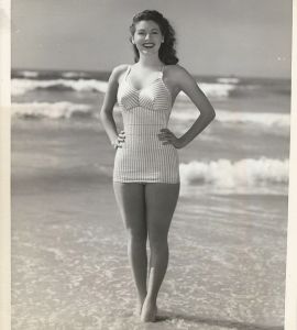 AVA GARDNER (1944) Early beach portrait with news snipe